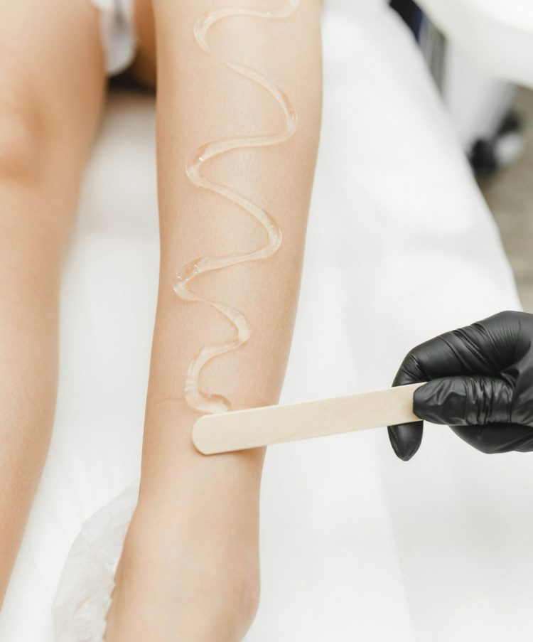 beautician applies gel for laser hair removal on smooth female legs. close-up. laser hair removal